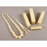 Six pieces of ivory. To include a graduated beaded necklace, glove stretchers and four brushes.