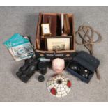 A box of miscellaneous. Includes carpet beater, boules, camera lenses, pictures, rock salt lamp (