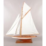 A model of a sail boat raised on a plinth. 93cm