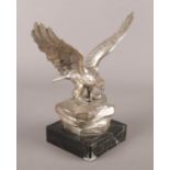 A white metal sculpture of an eagle raised on marble base. 22cm.