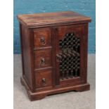 A hardwood cabinet with iron panelled door. (76cm x 62cm)