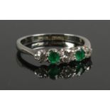 A ladies white gold and platinum ring set with alternating diamonds (3 x 1/8ct) and emeralds. Size