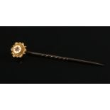 A boxed 15ct gold and diamond stick pin. L: 6cm. Gross weight: 1.69g. Approx. 1/32 ct diamond.