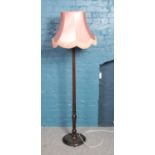 A mahogany standard lamp with circular base.