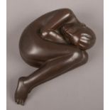 D.J Caldwell, a bronze figure of a curled nude. Signed to base.