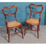 A pair of carved mahogany balloon back chairs with bergere seat.