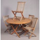 An outdoor wooden garden table and four matching folding chairs.