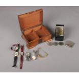 A hardwood cigarette/cigar box with assorted items. To include six ladies wrist watches (Pulsar,