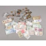 A box of mostly foreign pre decimal coins and banknotes. Including dimes, Rupee banknotes,