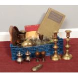A box of miscellaneous. Pair of brass candlesticks, silver plate salt and pepper pots. brass shoe