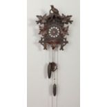 A carved wood black forest style cuckoo clock. Finial loose and in need of attention, no clock