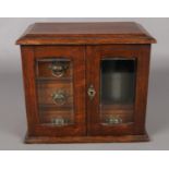 An oak smokers cabinet with contents. Including silver cigar cutter, pipes, etc.