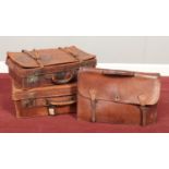Two vintage leather suitcases along with a leather satchel.