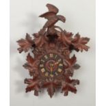 A carved wood black forest style cuckoo clock. Missing pendulum, weights and chains. Final loose.