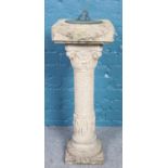 A cast concrete sundial. Decoration with figures to the column. (92cm)