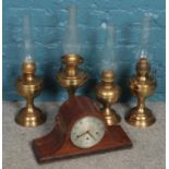 Four brass oil lamps along with a dome shape mantel clock with Haller movement.