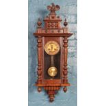 A mahogany Vienna wall clock, with turned spindles and finial depicting an eagle. In working
