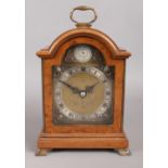An Elliott walnut cased mantle clock, with Tempus Fugit dial bearing Roman Numerals. Raised on brass