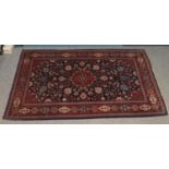 A blue ground wool rug with red border and floral decoration. (200cm x 142cm) Some ware to the