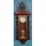 A carved mahogany Vienna wall clock hourly chiming on a coiled gong, the pediment decorated with