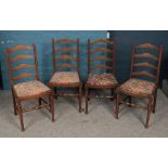 A set of four oak ladder back dining chairs.