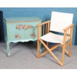 A pine directors chair with canvas seat, alongside a small one over two drawer side table with