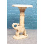 A alabaster carved side table with elephant figure to base. (63cm height 40cm width)