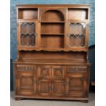 An Old Charm carved oak dresser. With lead glazed panels and secretaire to base.