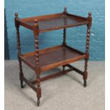 An oak two tier tea trolley with barley twist supports.