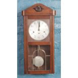 An oak cased wall clock with silvered dial.