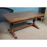 An Old Charm carved oak refectory dining table raised on turned and carved pineapple supports.