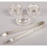 A pair of early 20th century Swedish silver sugar tongs along with three silver rimmed glass jars.