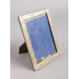 A silver photo frame, stamped 925, with floral decoration. Reverse of frame stamped 'Made in Italy'.