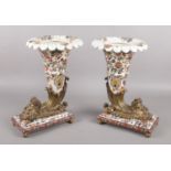 A pair of Wong Lee (WL 1895) ceramic and brass cornucopia; raised on rectangular base with turned