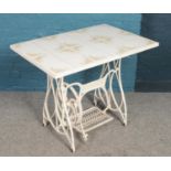 A tredle sewing table. Painted cast iron base with tile top. 75cm height 92cm width.