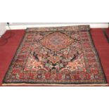 A blue ground wool rug with red border and floral decoration. (147cm x 215cm)