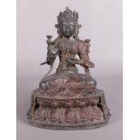 A Chinese bronze devotional figure raised on lotus plinth. Character marks to back. 23cm.
