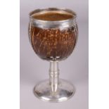 A 19th century coconut cup with white metal mounts and pedestal base. Height 17cm.