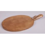 Robert 'Mouseman' Thompson, a carved oak oval cheese board. The handle with mouse signature. 40cm