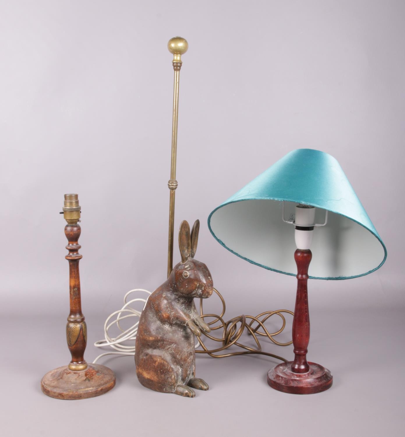 Two hardwood table lamps and an antique carved wooden rabbit and brass doorstop: H:63cm. Paint