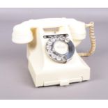A cream vintage rotary telephone. Crack to the back of the base.