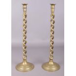 A pair of tall brass candlesticks with twisted stem. 53cm high. Small hole to the base on one