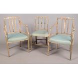 A set of three antique painted Hepplewhite style chairs, including two arm chairs. Paint peeling.