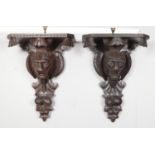 A pair of large carved hardwood corbel wall brackets with carved lion mask, fruit and foliage