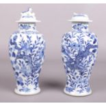 A pair of Chinese blue and white lidded baluster shape vases. Decorated with dragons and flowers.