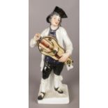 After Meissen, a continental Cries of Paris figure of a man with a hurdy gurdy. Missing 1st & 2nd