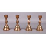 A set of four bronzed candlesticks. 15.5cm high.