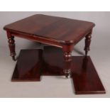 A Victorian mahogany wind out dining table, with carved legs and two additional leaves. Raised on