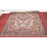 A cream ground wool rug with multi-coloured floral border. 143cm x 212cm
