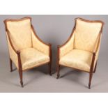 A pair of Edwardian mahogany tub arm chairs.